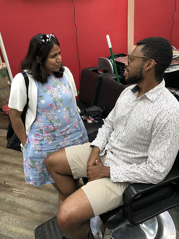 Dr. Mona Mittal talks to a barbershop customer. 