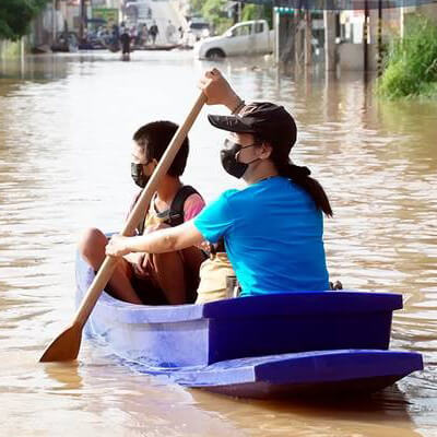 NIH Climate Change and Health Initiative and Strategic Framework cover shows a boy in a small boat as an Asian woman rows it down a flooded street