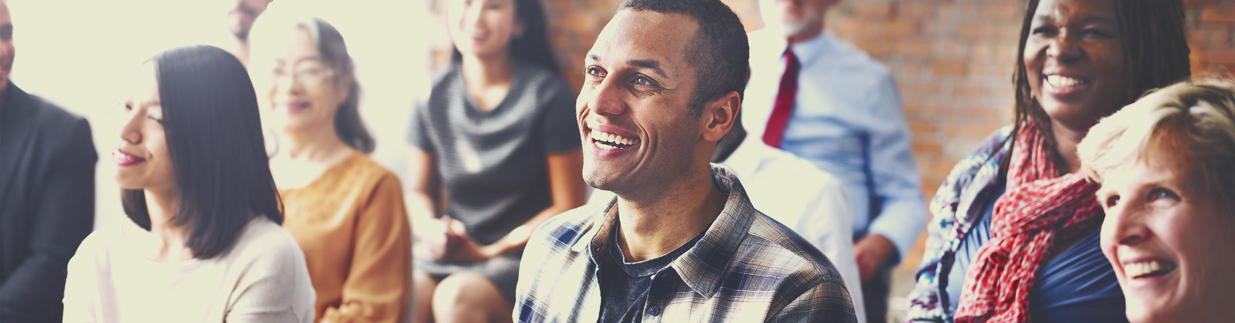 A diverse group of men and women react positively to a speaker