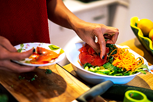 Photo of a person picking through a salad with their fingers.