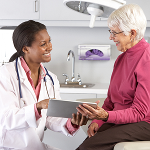 Black woman clinician talking with older female patient